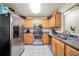 Kitchen with stainless steel appliances, tile floors, and wood cabinetry at 502 Gallantry Trl, Mcdonough, GA 30252