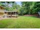Large, green backyard with screened porch, grill, and mature trees at 9685 Cone Ct, Roswell, GA 30075