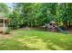 Spacious backyard featuring a playset, lush lawn, and mature trees at 9685 Cone Ct, Roswell, GA 30075