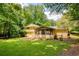 Beautiful backyard featuring a screened porch, lush lawn, and mature trees at 9685 Cone Ct, Roswell, GA 30075
