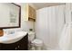 Bright bathroom with a vanity, commode, and shower behind a white curtain at 9685 Cone Ct, Roswell, GA 30075