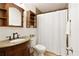Bathroom with granite countertop, vanity, and shower behind a white curtain at 9685 Cone Ct, Roswell, GA 30075
