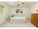 A bright bedroom features a ceiling fan, artwork above the bed, and a window that allows natural light at 9685 Cone Ct, Roswell, GA 30075