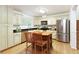 Well-appointed kitchen featuring a center island, stainless steel appliances, granite countertops, and ample cabinet space at 9685 Cone Ct, Roswell, GA 30075