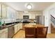 Bright kitchen showcasing granite countertops, stainless steel appliances, a center island, and hardwood flooring at 9685 Cone Ct, Roswell, GA 30075