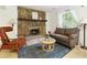 Cozy living room boasts a stone fireplace, hardwood floors, and ample seating at 9685 Cone Ct, Roswell, GA 30075
