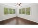 Bedroom featuring hardwood floors, ceiling fan and multiple windows with views of the surrounding trees at 127 Sanctuary Ave, Woodstock, GA 30188
