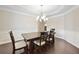 Elegant dining room with classic wainscoting, chandelier lighting, and a large table for Gathering gatherings at 127 Sanctuary Ave, Woodstock, GA 30188