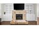 Beautiful stone fireplace featuring built-in bookshelves with ample storage and display space at 127 Sanctuary Ave, Woodstock, GA 30188