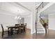 Bright foyer with dark wood floors, staircase and wainscoting leading to the dining room with chandelier at 127 Sanctuary Ave, Woodstock, GA 30188