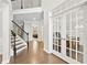 Bright foyer with hardwood floors, French doors to office, and staircase with iron balusters at 127 Sanctuary Ave, Woodstock, GA 30188