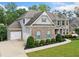 Elegant two-story home boasts a two-car garage, brick facade, and professionally landscaped yard at 127 Sanctuary Ave, Woodstock, GA 30188