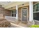 Charming covered front porch featuring brick columns, white railings, and a cozy welcome mat at 127 Sanctuary Ave, Woodstock, GA 30188