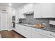 Modern kitchen cooktop and surrounding counters with a stainless vent hood and modern backsplash at 127 Sanctuary Ave, Woodstock, GA 30188