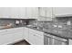 Close up on the kitchen featuring granite countertops, mosaic tile backsplash, and stainless steel dishwasher at 127 Sanctuary Ave, Woodstock, GA 30188