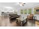 Open concept living room with hardwood floors, large windows and view of the kitchen and breakfast bar at 127 Sanctuary Ave, Woodstock, GA 30188