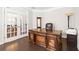 Elegant office space featuring a large wooden desk, French doors, and hardwood flooring at 127 Sanctuary Ave, Woodstock, GA 30188