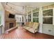 Inviting covered patio featuring a brick fireplace, comfortable seating, and ceiling fan at 127 Sanctuary Ave, Woodstock, GA 30188