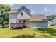 View of home's backyard with a wooden deck, green lawn, and trees at 3037 Botany Dr, Jonesboro, GA 30236