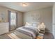 A cozy bedroom features a double bed, neutral colors, lamps and artwork at 3037 Botany Dr, Jonesboro, GA 30236