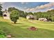 Grassy backyard featuring a fire pit and a view of the nearby homes in the neighborhood at 501 Grace Ct, Temple, GA 30179