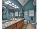 Bathroom with double sink vanity, framed mirror, shower with glass door, and decorative shelving at 501 Grace Ct, Temple, GA 30179