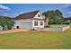 Side view of the home showcasing the garage, white picket fence, and expansive yard at 501 Grace Ct, Temple, GA 30179
