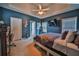 This spacious main bedroom features a tray ceiling, fan, wall-mounted television, and calming blue walls at 501 Grace Ct, Temple, GA 30179