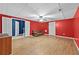 Finished basement with red accent wall, tiled ceiling, small couch and hardwood floors at 1920 Lee Patrick Dr, Dacula, GA 30019