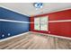 Bedroom with red and blue accent walls, and hardwood flooring at 1920 Lee Patrick Dr, Dacula, GA 30019