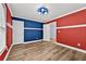 Bedroom featuring red and blue accent walls with hardwood floors and a unique ceiling fan at 1920 Lee Patrick Dr, Dacula, GA 30019