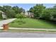 Traditional two-story brick home with a red front door and lush green lawn, showcasing curb appeal at 1920 Lee Patrick Dr, Dacula, GA 30019