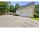 Exterior shot of the side of the house, showing a two-car garage and expansive driveway at 1920 Lee Patrick Dr, Dacula, GA 30019