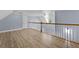 Second floor hallway with hardwood floors and a decorative railing at 1920 Lee Patrick Dr, Dacula, GA 30019