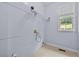 Plainly painted laundry room with window and wire shelving at 1920 Lee Patrick Dr, Dacula, GA 30019