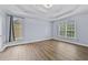 Spacious main bedroom featuring hardwood floors, two large windows, and a tray ceiling at 1920 Lee Patrick Dr, Dacula, GA 30019