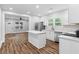 Open kitchen with stainless steel appliances, white cabinets, and a spacious island overlooking the living area at 2209 Browns Mill Se Rd, Atlanta, GA 30315