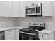 Close-up view of a modern kitchen with stainless steel microwave and cooktop stove at 2209 Browns Mill Se Rd, Atlanta, GA 30315