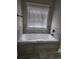 Bathroom showing a tile-surrounded soaking tub with a window view at 2439 Muirfield Pl, Atlanta, GA 30337