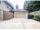 Exterior view of a spacious two-car garage with concrete driveway and neatly landscaped surroundings at 2439 Muirfield Pl, Atlanta, GA 30337