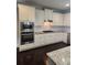 Modern kitchen with stainless steel appliances, white cabinetry, granite countertops, and hardwood floors at 2439 Muirfield Pl, Atlanta, GA 30337