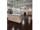 Open kitchen with a center island with granite countertop and dark hardwood floors overlooking the living area at 2439 Muirfield Pl, Atlanta, GA 30337