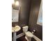 Modern powder room featuring dark walls, wood-look floors, and a pedestal sink at 2439 Muirfield Pl, Atlanta, GA 30337