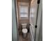 Compact powder room featuring a toilet and window at 2439 Muirfield Pl, Atlanta, GA 30337