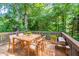 Outdoor back deck with wood table and seating overlooking wooded area at 310 Rippling Brook Trce, Palmetto, GA 30268