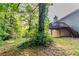View of the home's exterior and back deck from backyard with mature trees at 310 Rippling Brook Trce, Palmetto, GA 30268