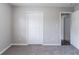 This bedroom has neutral carpet, natural light, and a closet at 310 Rippling Brook Trce, Palmetto, GA 30268