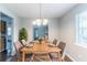 Dining room with a chandelier above a wooden table set with plates and chairs at 310 Rippling Brook Trce, Palmetto, GA 30268