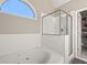 Elegant bathroom featuring a soaking tub, glass shower, and natural light from a window at 4186 Stillwater Pt, Ellenwood, GA 30294