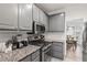 Close-up of a kitchen area featuring gray granite countertops, stainless steel appliances and cabinetry at 4186 Stillwater Pt, Ellenwood, GA 30294
